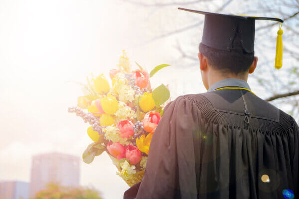 male graduate with a graduation bouquet