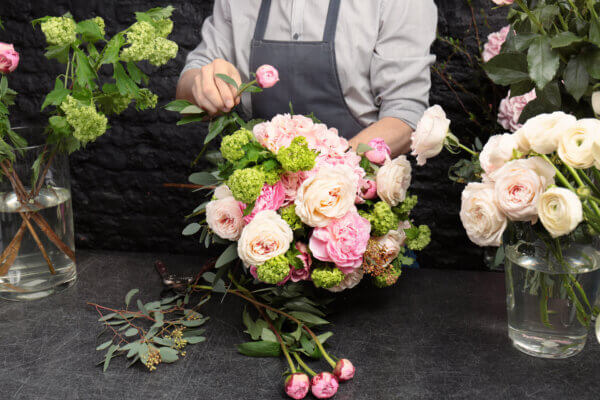 Florist arranging pink and white roses.